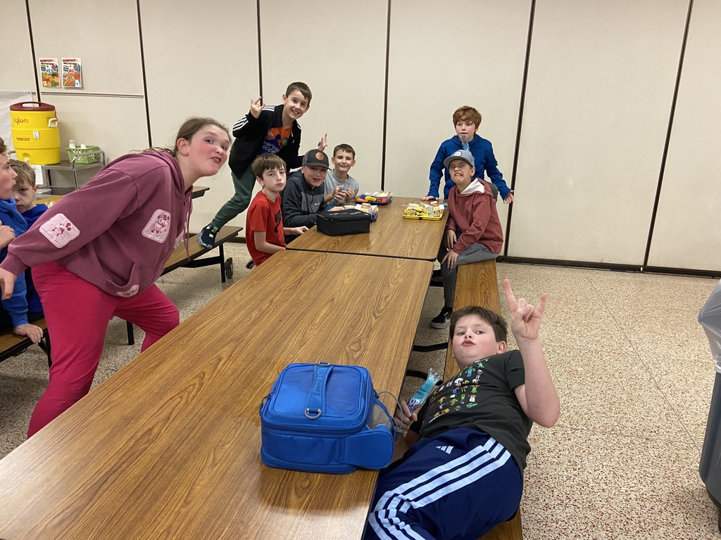 students sitting at a lunch table smiling
