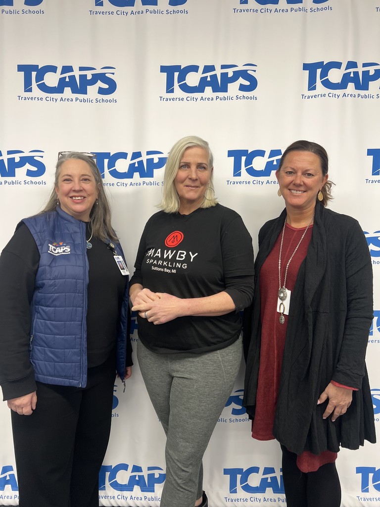 3 women from tcaps and mawby standing in front of tcaps logo sign