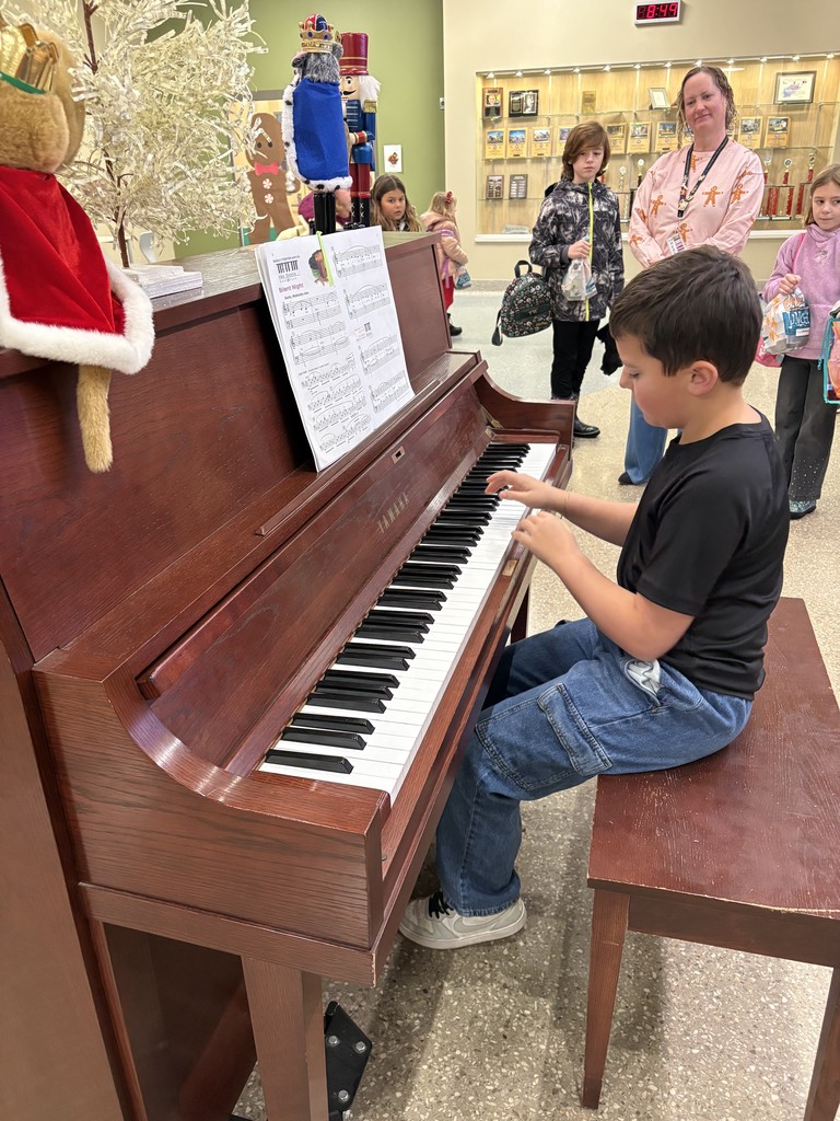 Maxton playing the piano in the Eastern school lobby