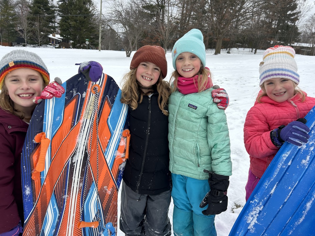 Four second grade girls with sleds