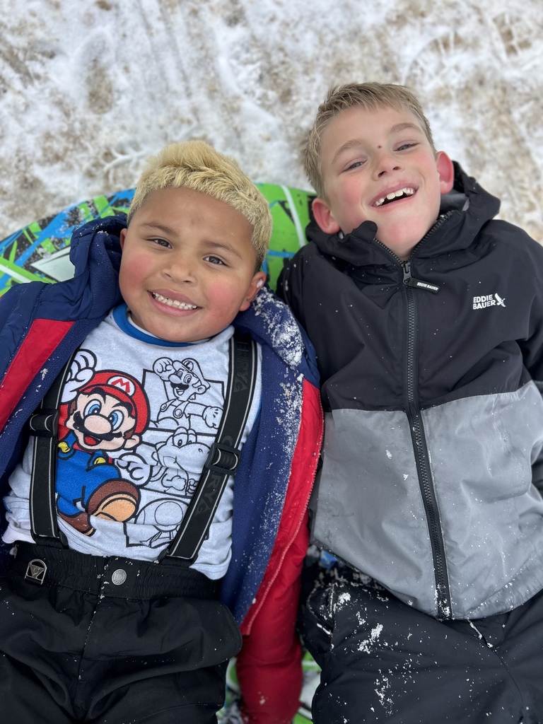Second grade boys laying in the snow