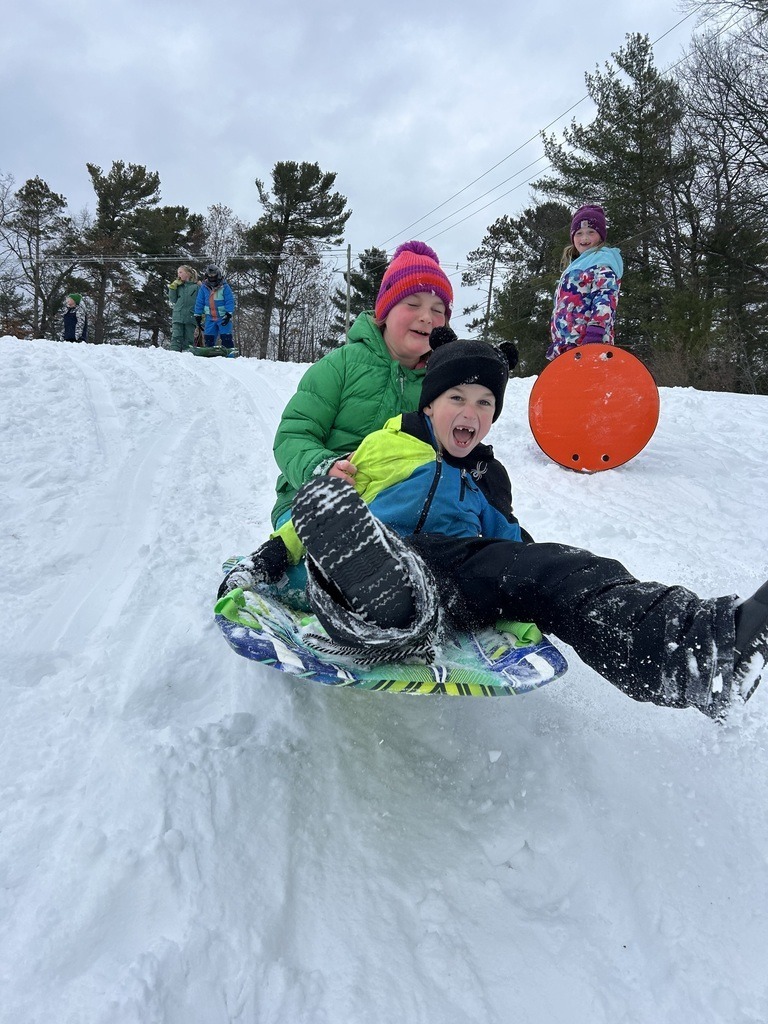 Students sledding down a hill