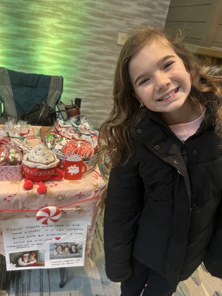 Student standing in front of her hot cocoa stand