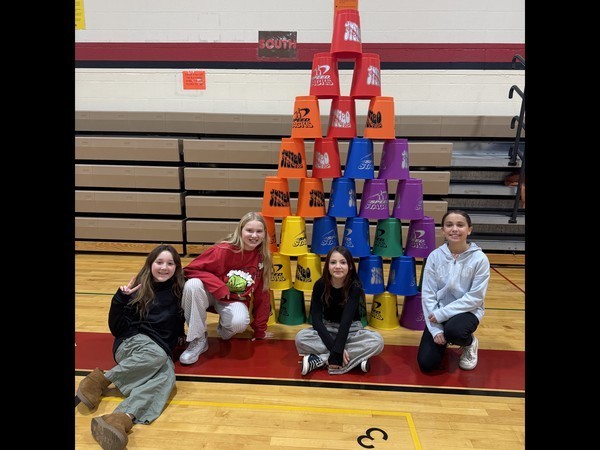 fifth grade students standing by stacked cups