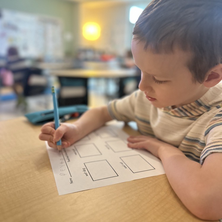 student writing at his desk