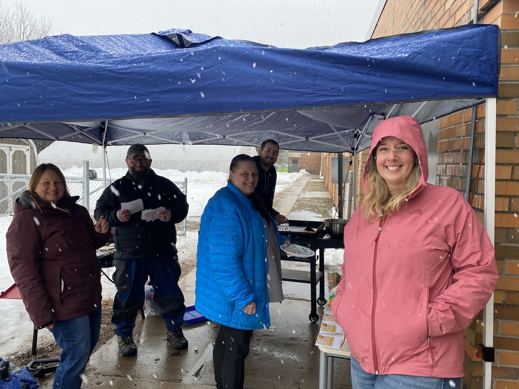 Parents  and Mr. Steele outside making pancakes for the 5th graders