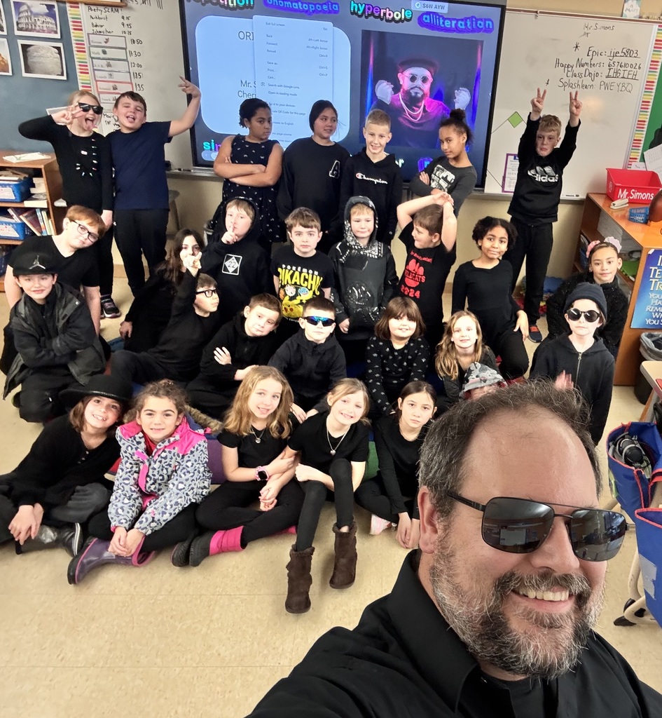 adult wearing sunglasses taking a selfie of students wearing black in the background