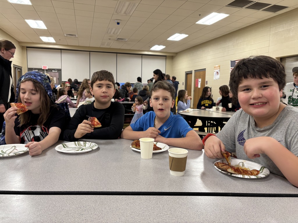 Four boys eating pizza