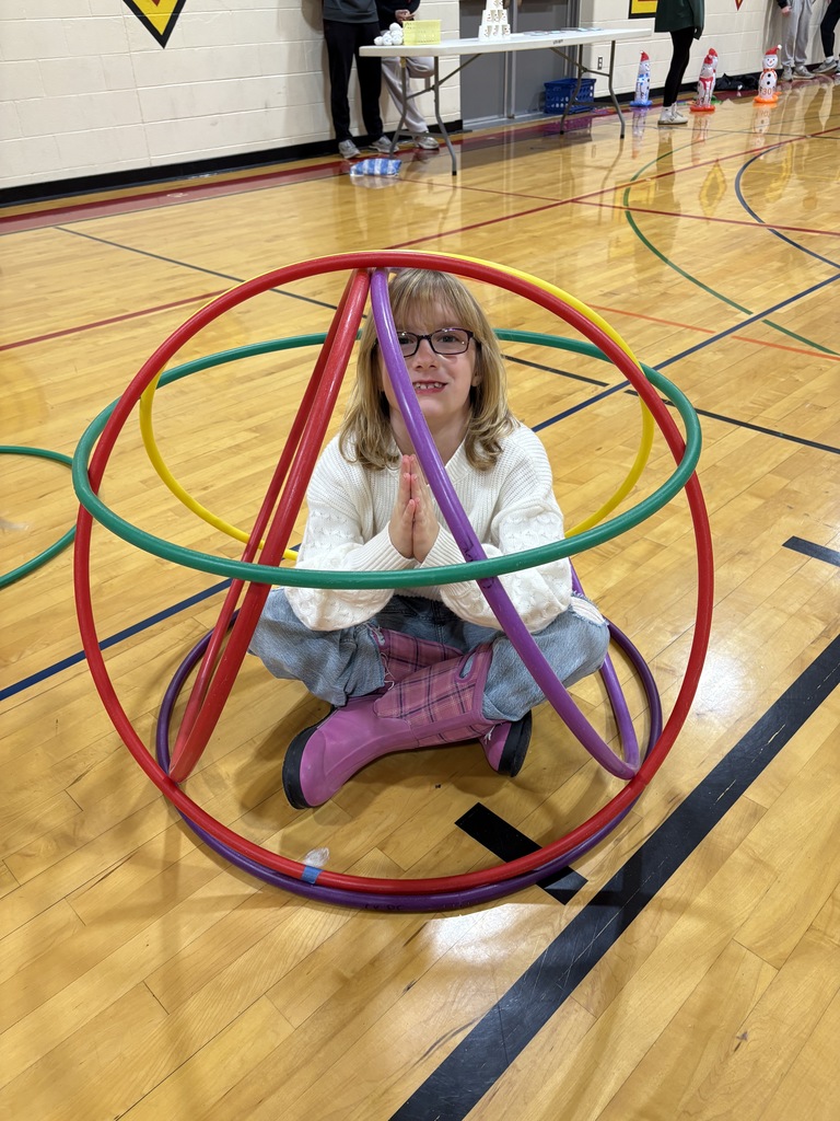 a girl sitting with legs crossed inside of a hula hoop creation
