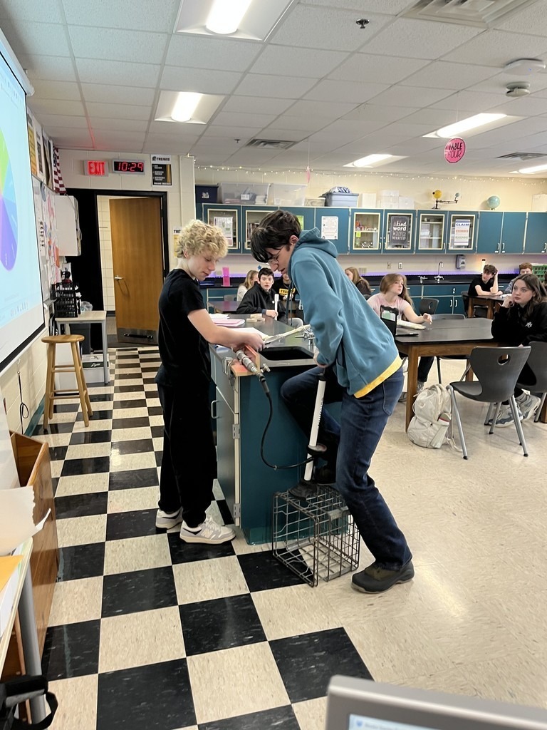 Two students showing their science experiment in the classroom