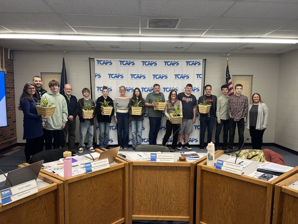 Students and Board Members standing together with their gifted plant holders