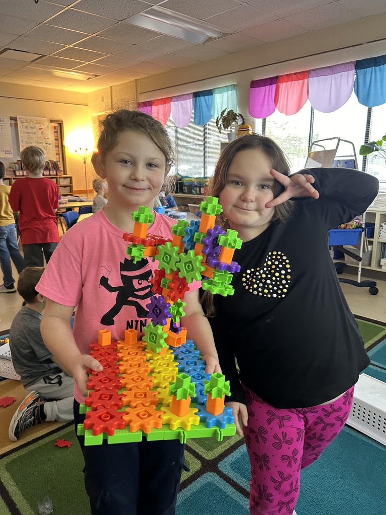 Two students holding blocks, one student giving the peace sign