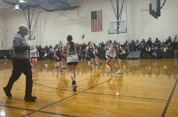 Girls Basketball Game with players in action and official