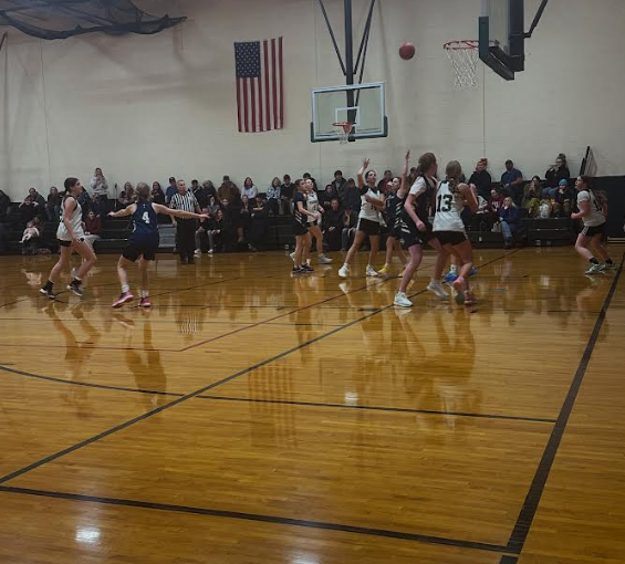 Girls Basketball Game with players in action and official
