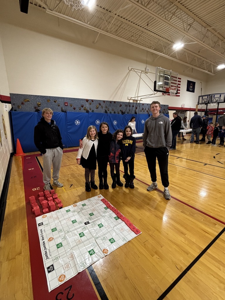 students in the gym playing games with the volunteers