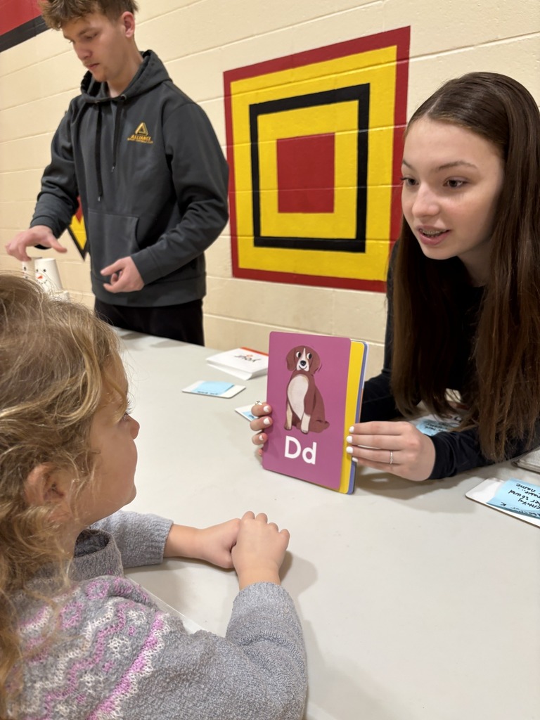 Volunteers playing games with students at a table