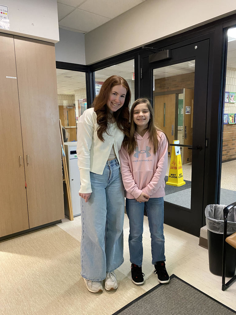 Volunteer from Big Brothers Big sisters standing with a student in the hallway