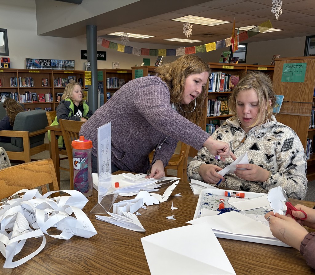 Volunteer doing crafts with students at a table