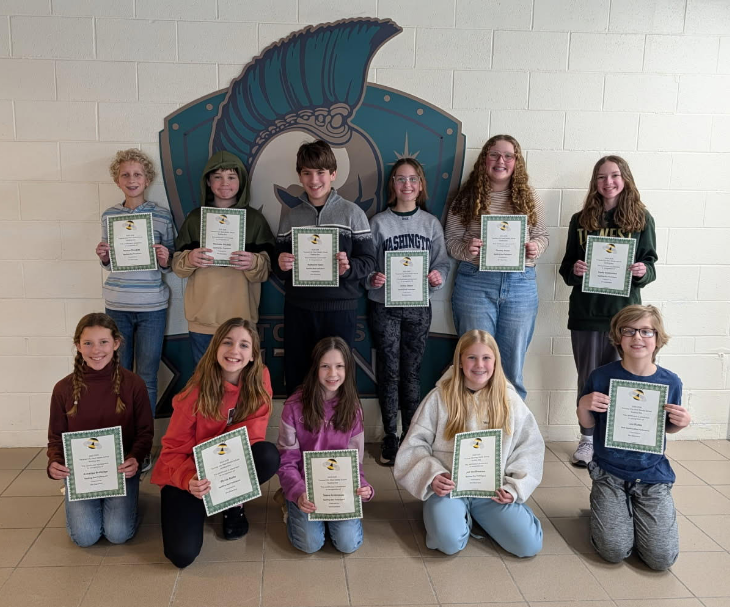 Group photo of spelling bee participants standing in front of our Titan logo