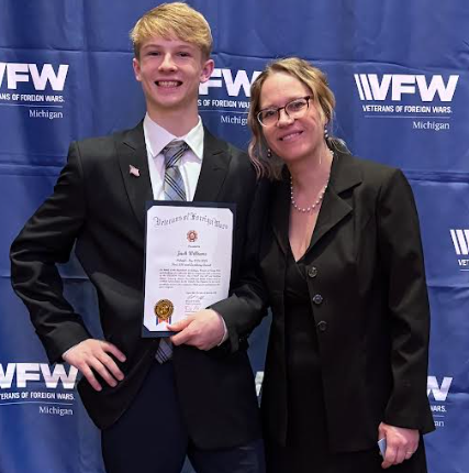 Jack standing with his mom and award