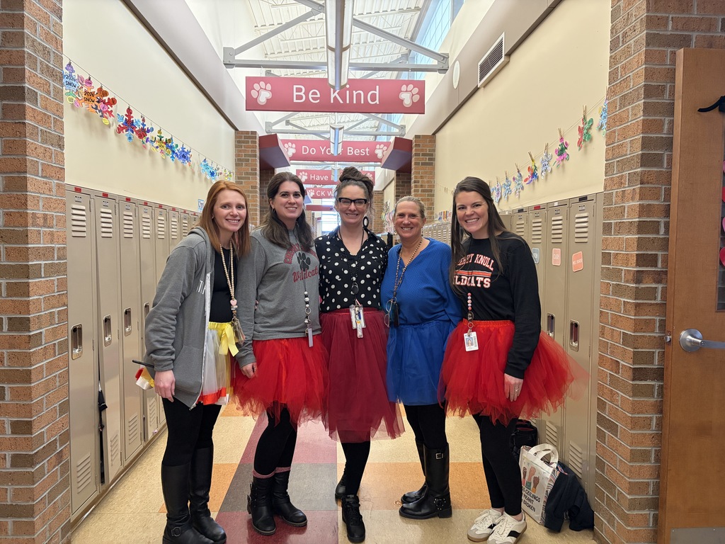 Five teachers standing in hallway wearing tutus