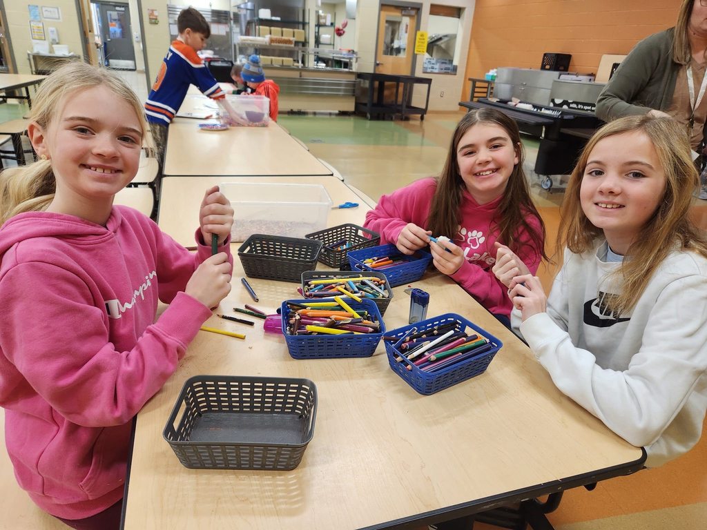 Students sitting at a table sharpening pencils