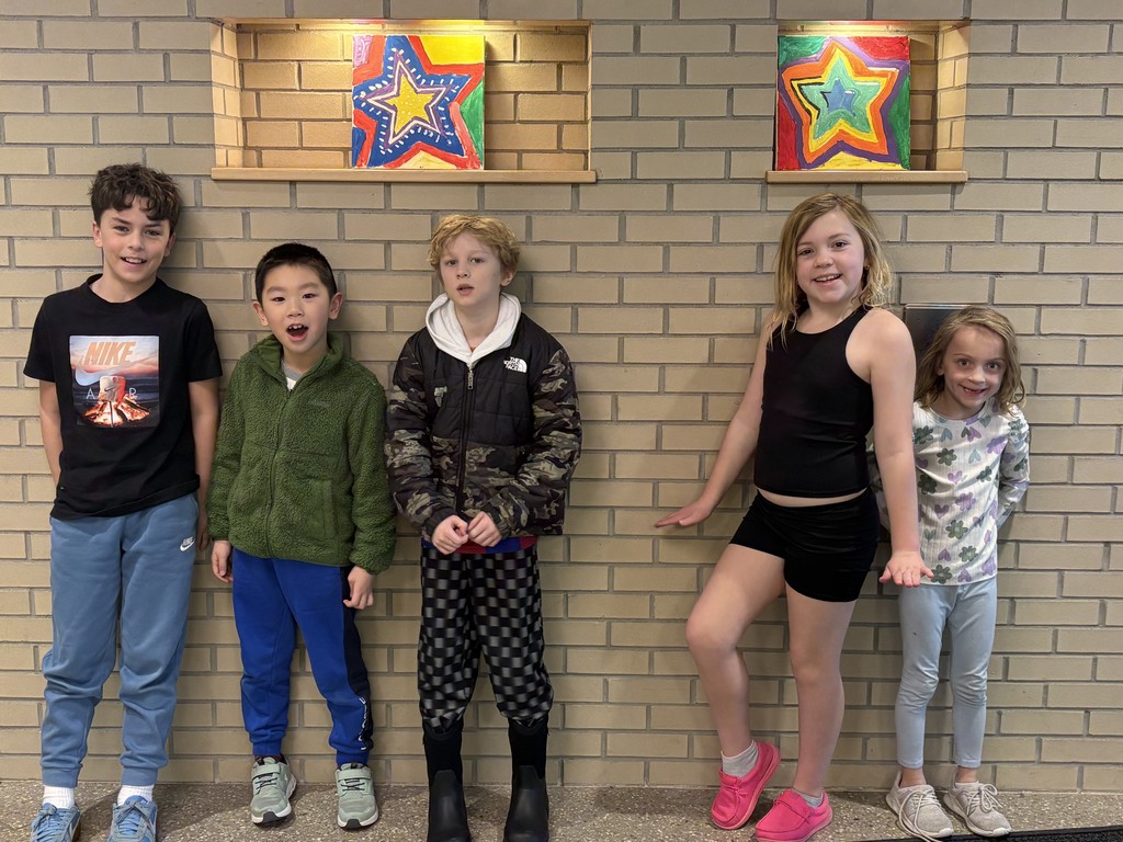 Five students standing against a wall