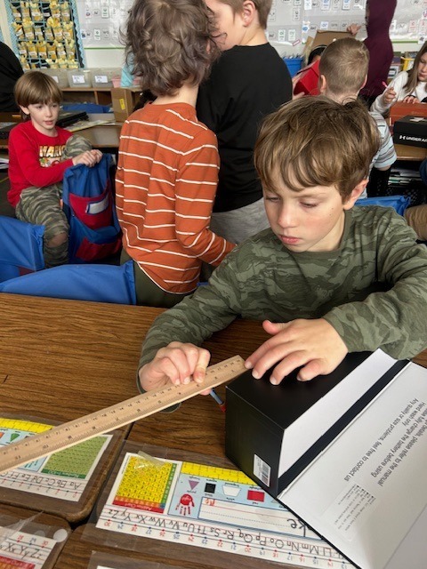 Student measuring his Valentine box