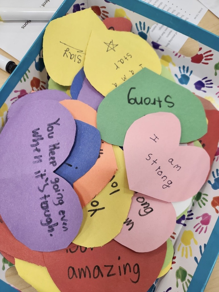Cut out paper hearts with handwritten notes on them