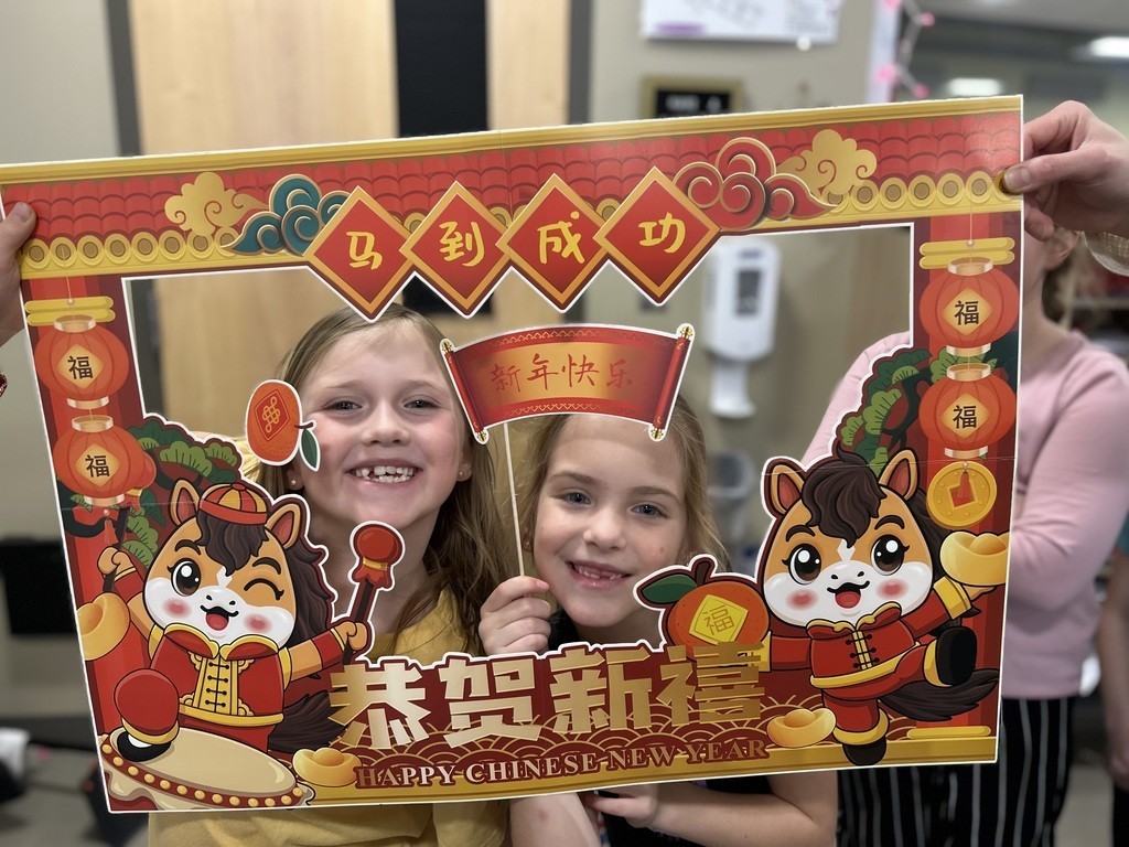 student holding a Chinese New Year frame in front of them