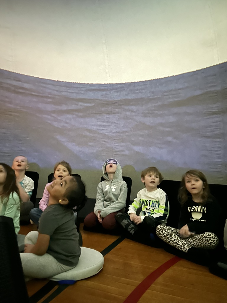 students sitting on the floor, looking at ceiling