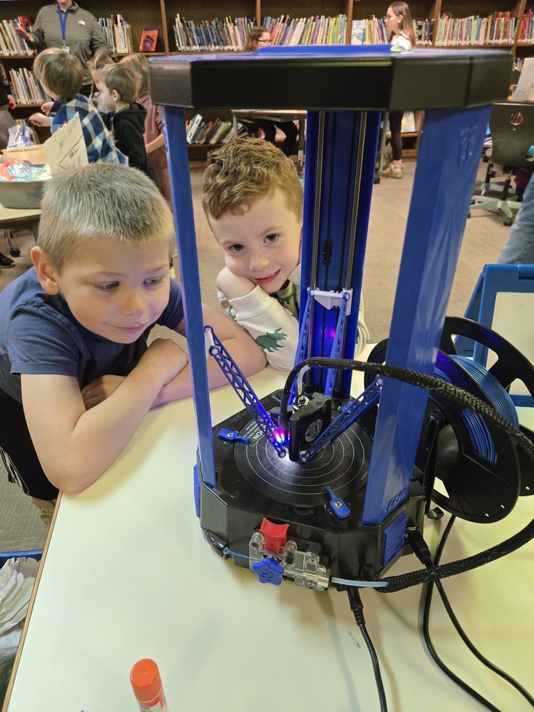 two students observing a robotic system