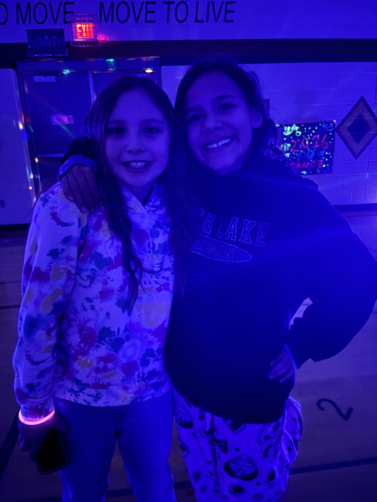 two girls standing in a gym with arms around each other