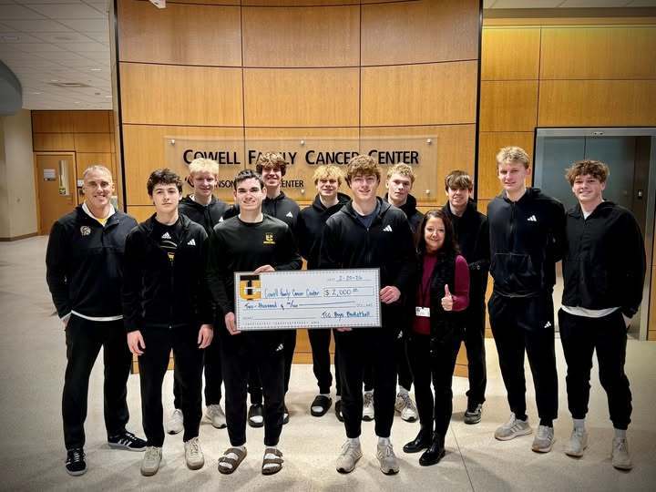 Boys basketball team presenting check to hospital