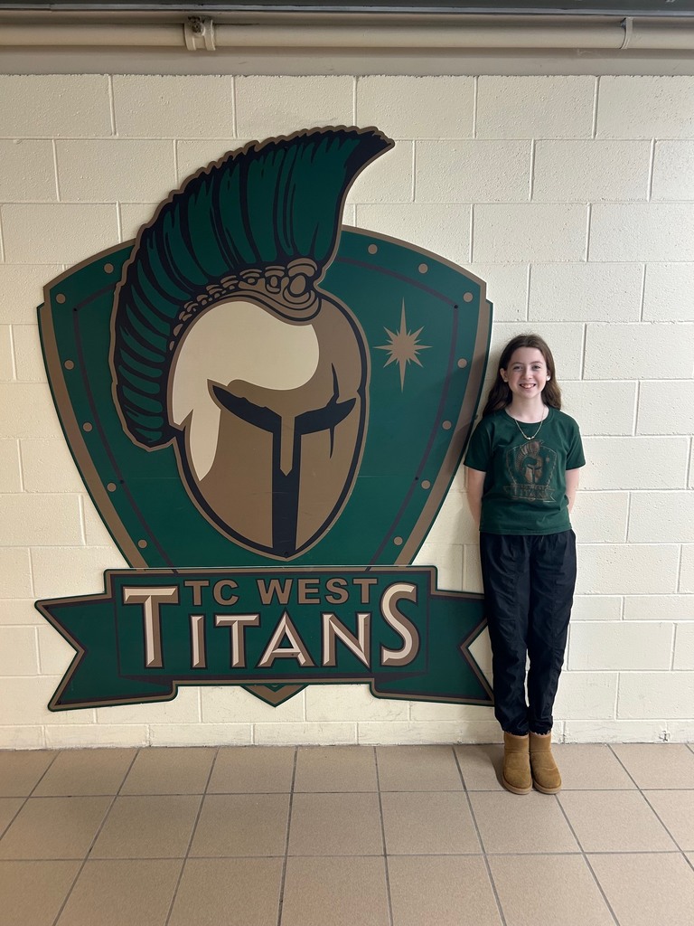 Elena Tamlyn standing to the right of the Titan shield