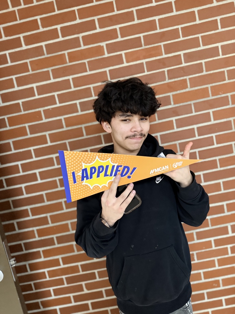 TCHS student holds up an "I applied" banner after applying at NMC.