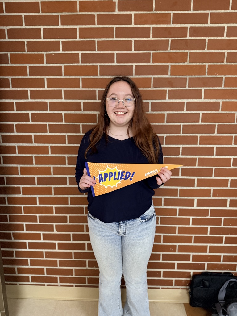 TCHS student holds up an "I applied" banner after applying at NMC.