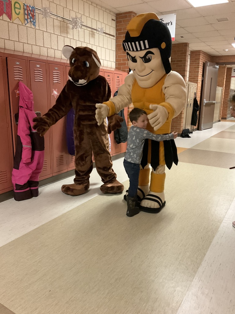 Two mascots with one kid hugging one of them.