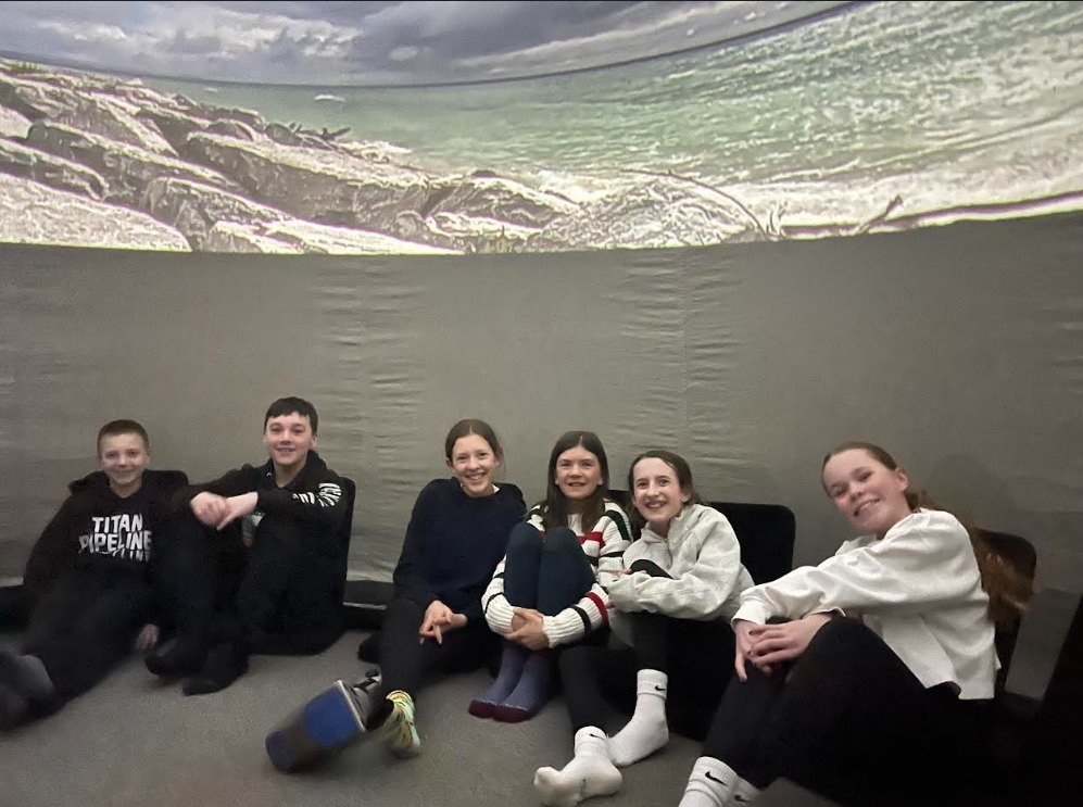Students sitting underneath the interactive dome