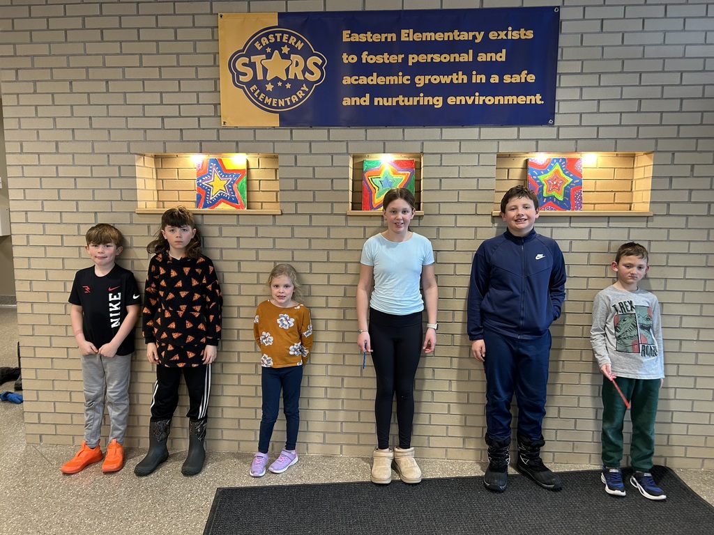 Six students in grades kindergarten through fifth grade standing against a school brick wall recognized as Eastern star students of the week.