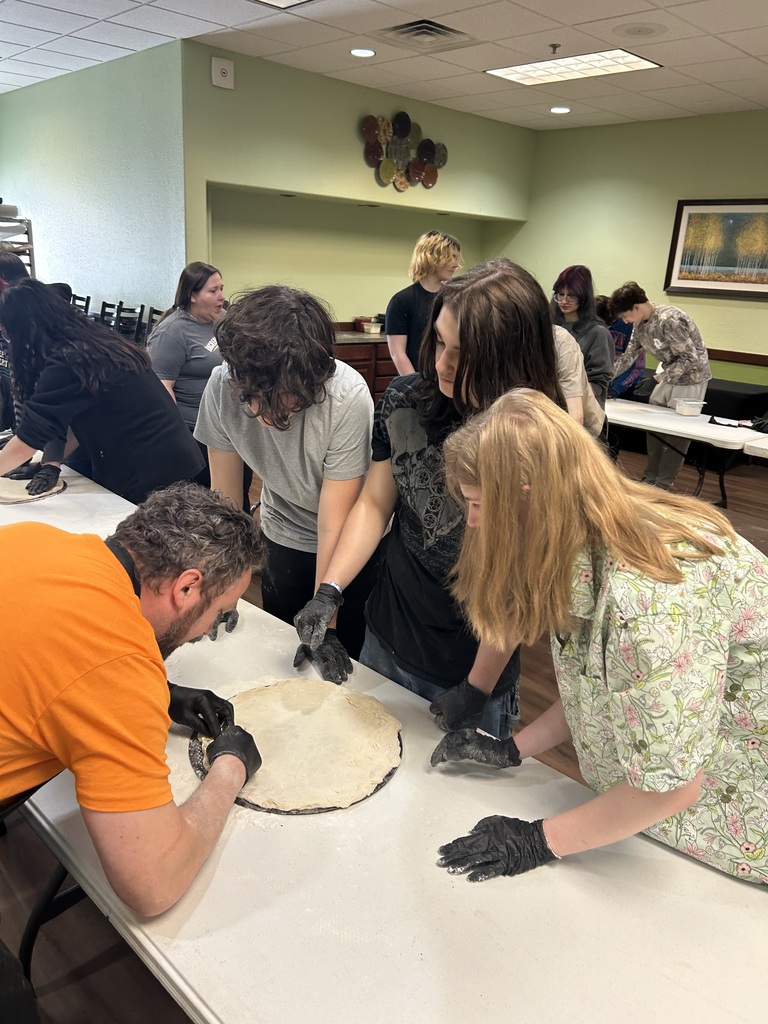 TCHS students make a custom pizza with the help of the Incredible Mo's staff