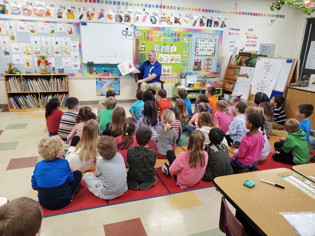 Superintendent reading to classroom full of students.