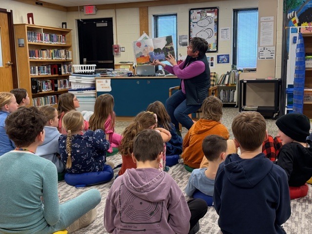 State Representative Betsy Coffia is reading to a group of students in the library for March is Reading Month.