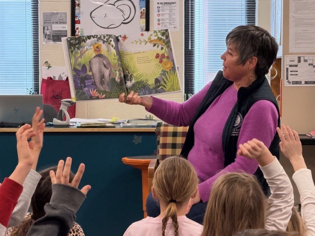 State Representative Betsy Coffia is reading to a group of students in the library for March is Reading Month.