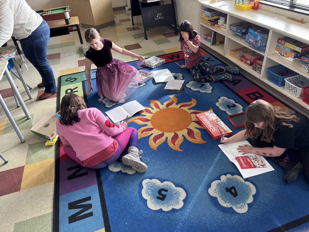 Four students exploring a variety of board games.