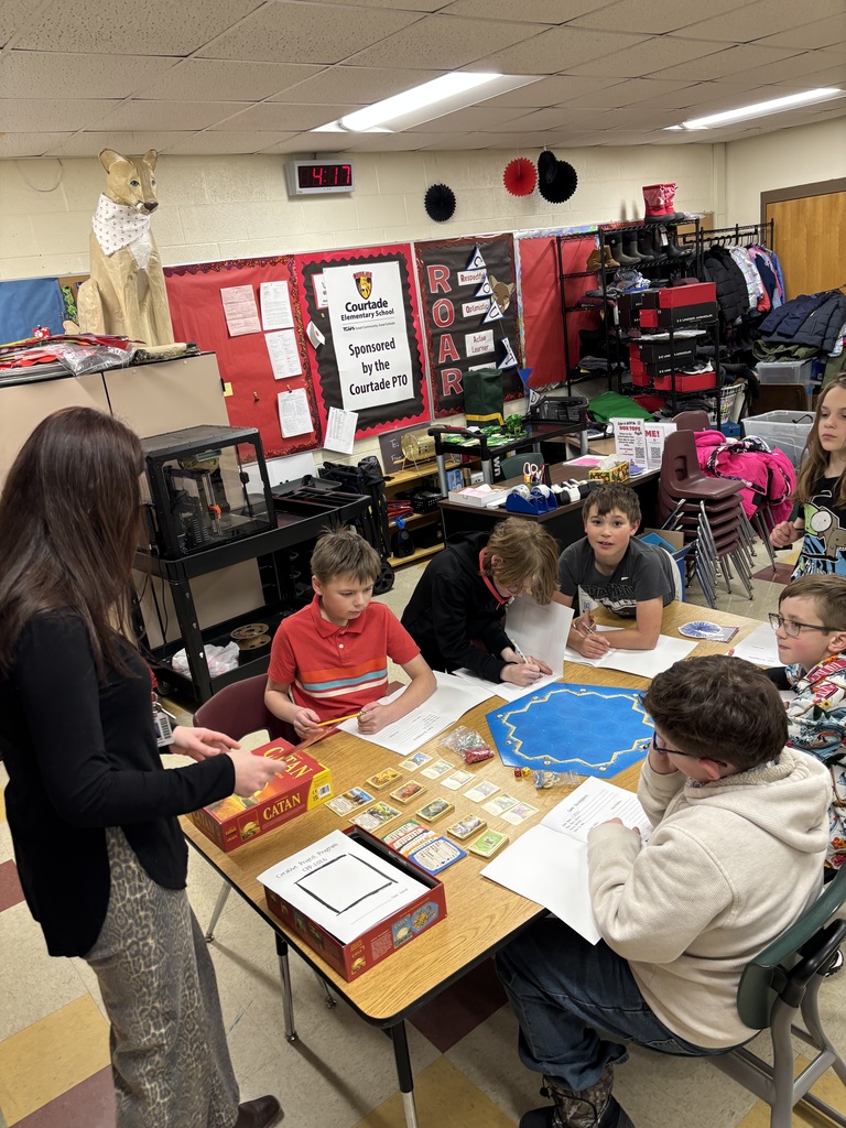 Teacher exploring the Catan board game with six students. 