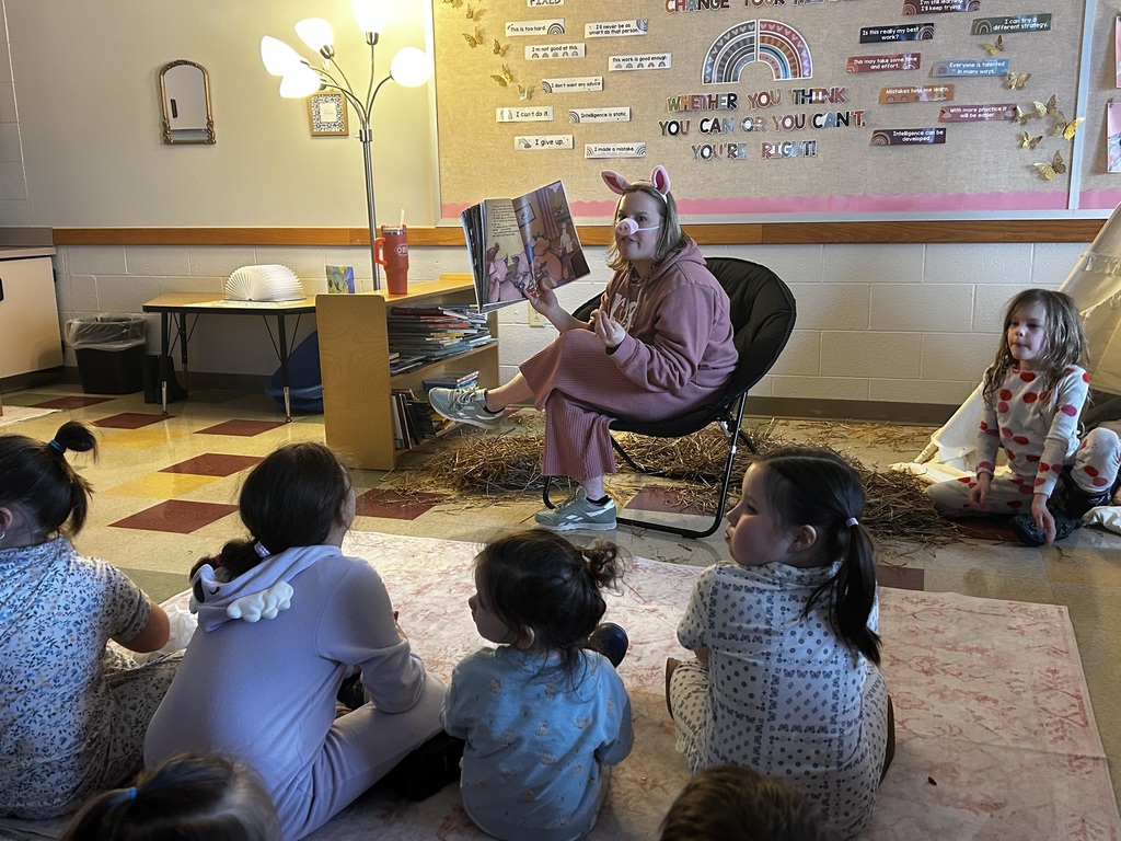 Teacher dressed as a pig reading The Three Little Pigs