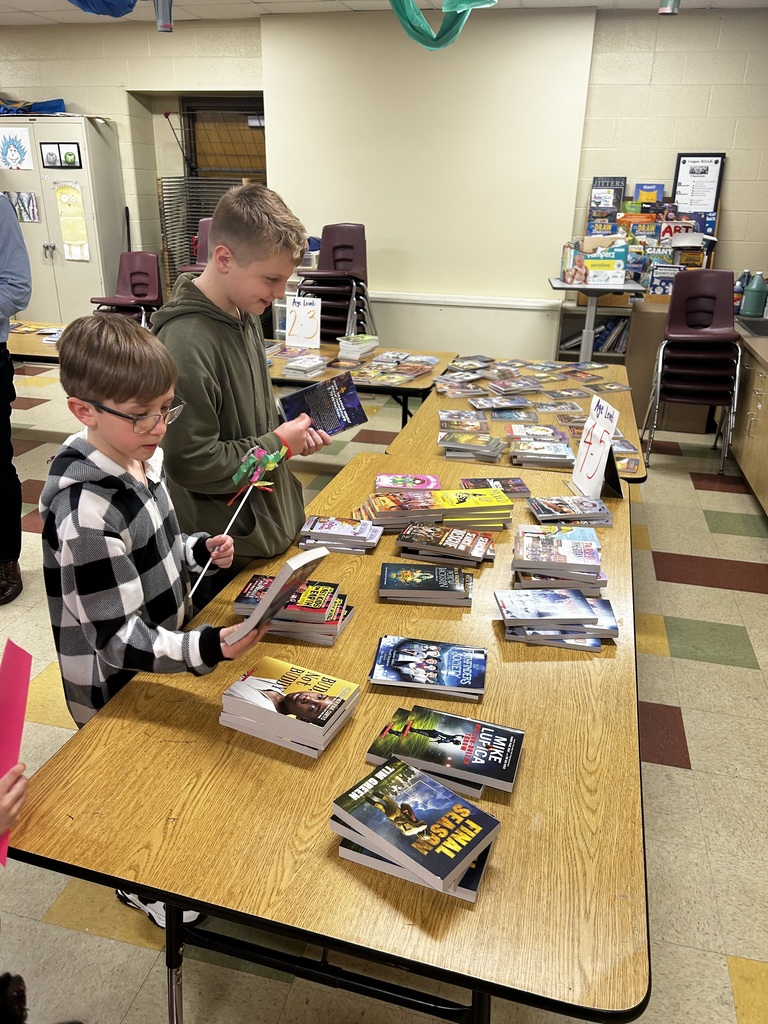Two kids picking out free books. 