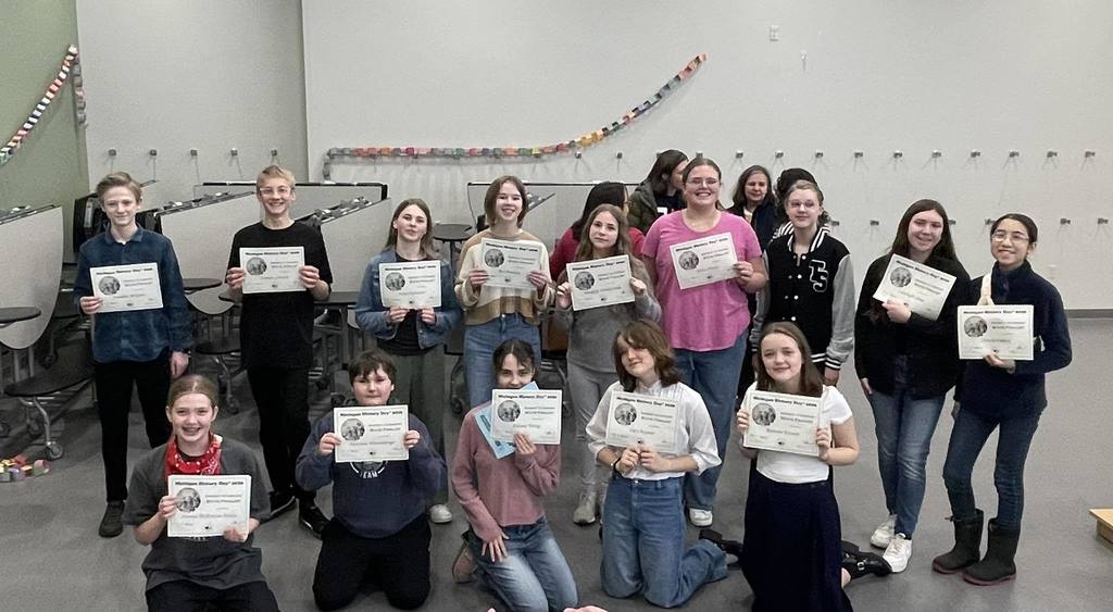 students standing together holding their certificates
