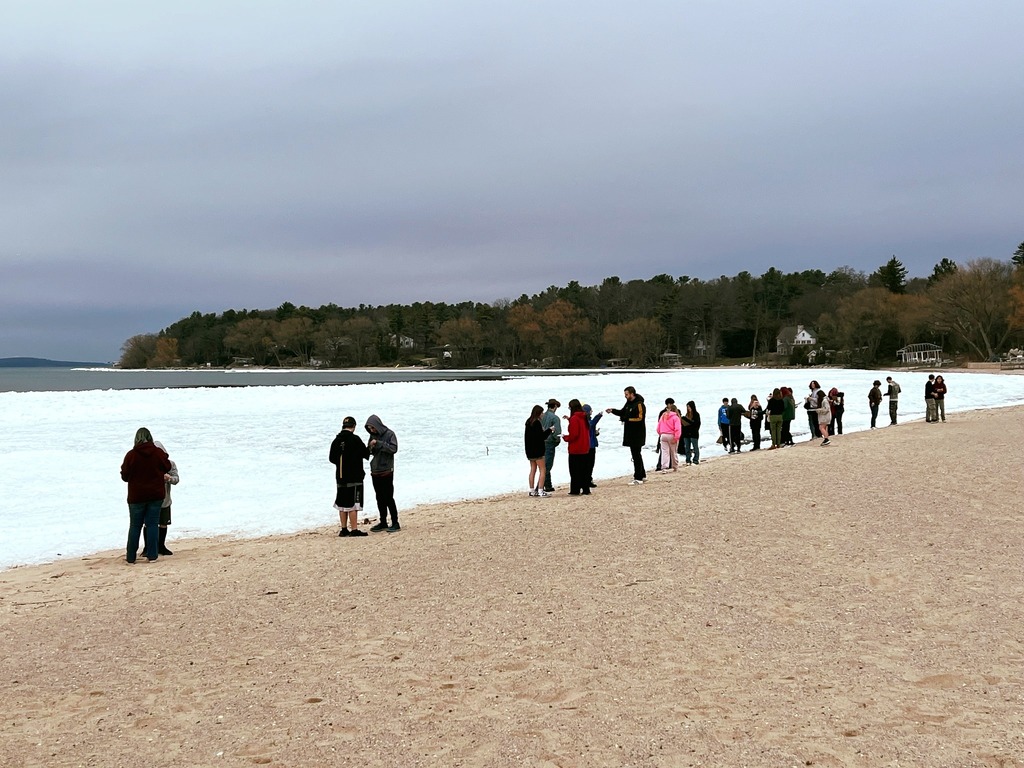 Students standing at the shore of the bay